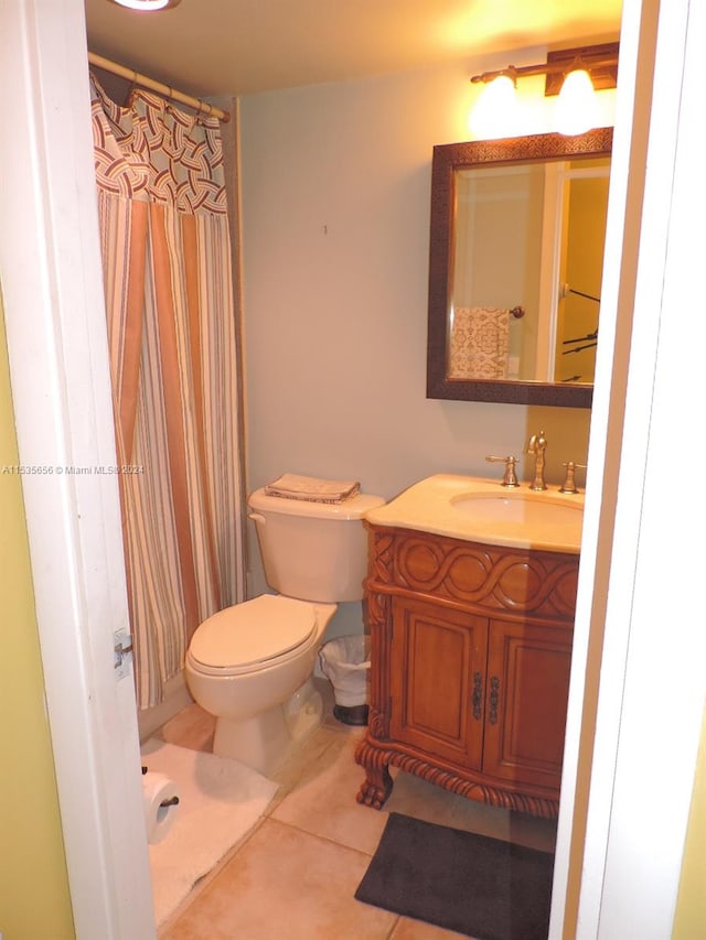 bathroom with toilet, tile floors, and vanity