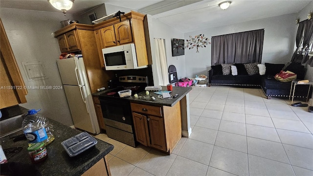 kitchen featuring white appliances, lofted ceiling, and light tile flooring