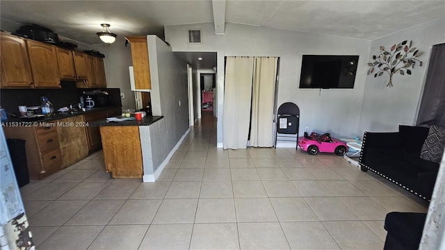 kitchen featuring light tile flooring and vaulted ceiling with beams