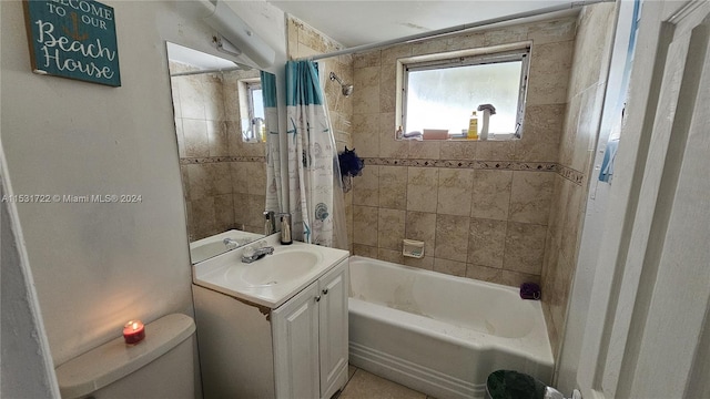 full bathroom with toilet, large vanity, and shower / tub combo