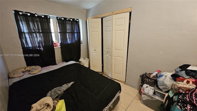 bedroom featuring light tile flooring and a closet