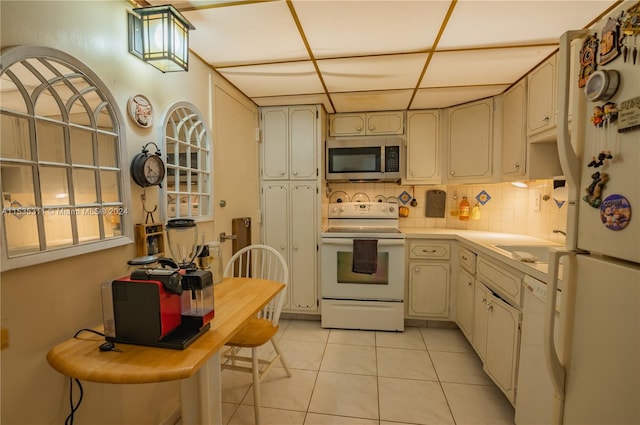 kitchen with white appliances, backsplash, and light tile flooring