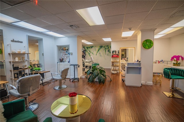 interior space featuring dark wood-type flooring and a drop ceiling