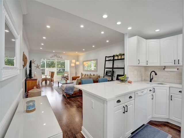 kitchen featuring dishwasher, dark hardwood / wood-style flooring, kitchen peninsula, and white cabinets