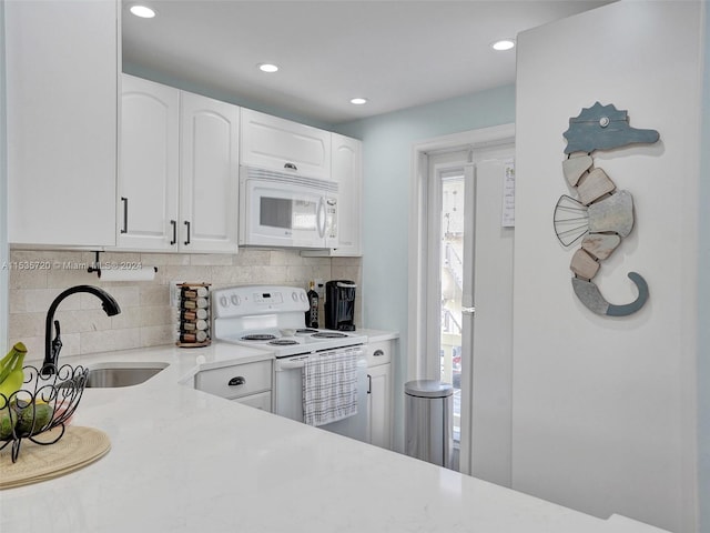 kitchen featuring backsplash, white cabinetry, white appliances, and sink