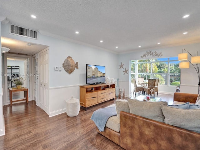 living room with a textured ceiling, dark hardwood / wood-style flooring, and crown molding