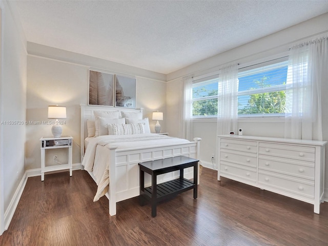 bedroom featuring a textured ceiling and dark wood-type flooring