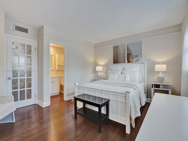 bedroom with a textured ceiling, dark hardwood / wood-style floors, and ensuite bathroom