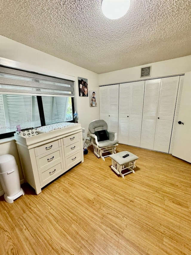 unfurnished bedroom featuring a closet, light hardwood / wood-style flooring, and a textured ceiling