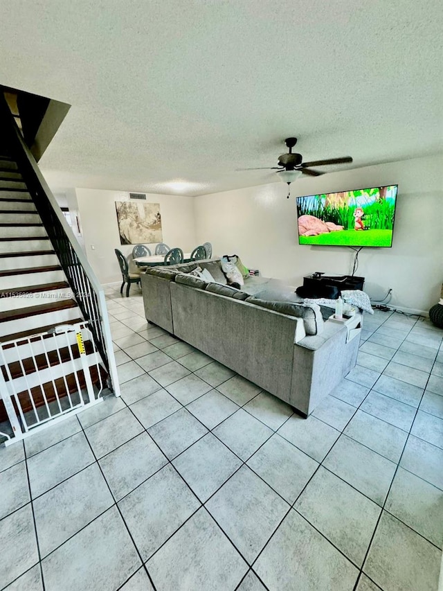 unfurnished living room featuring tile flooring, ceiling fan, and a textured ceiling