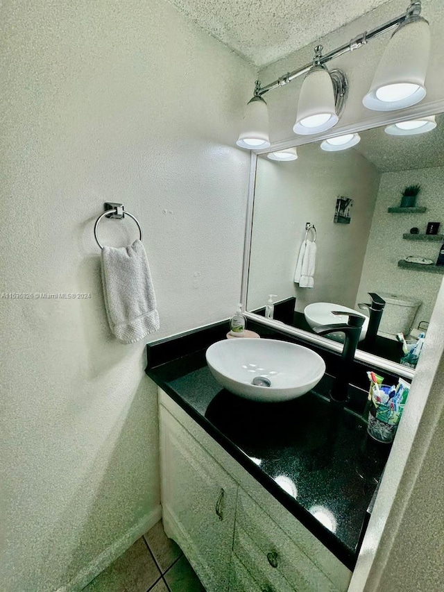 bathroom featuring tile flooring, vanity, and a textured ceiling