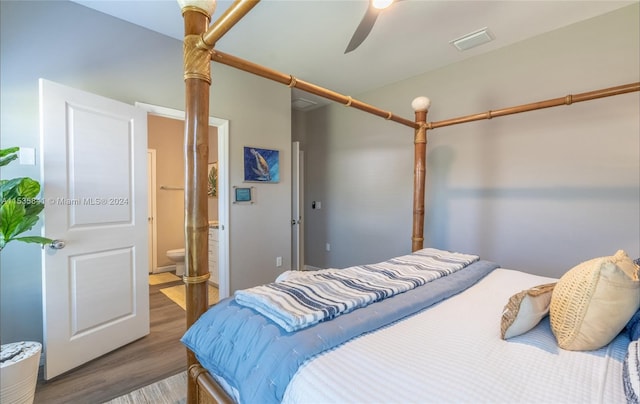 bedroom with ensuite bath, dark hardwood / wood-style floors, and ceiling fan