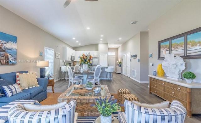 living room with plenty of natural light, dark hardwood / wood-style flooring, and lofted ceiling