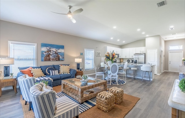 living room with lofted ceiling, light hardwood / wood-style floors, and ceiling fan