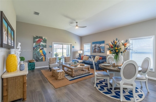 living room featuring lofted ceiling, dark wood-type flooring, and ceiling fan