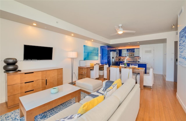 living room with light hardwood / wood-style flooring and ceiling fan