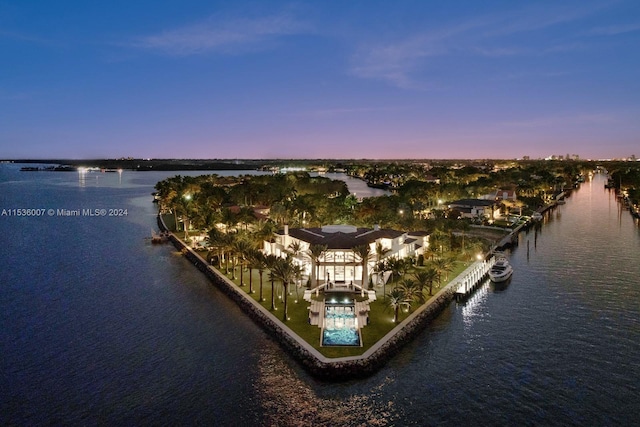 aerial view at dusk featuring a water view