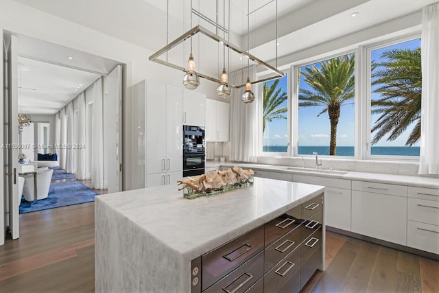 kitchen with decorative light fixtures, white cabinetry, and dark hardwood / wood-style floors