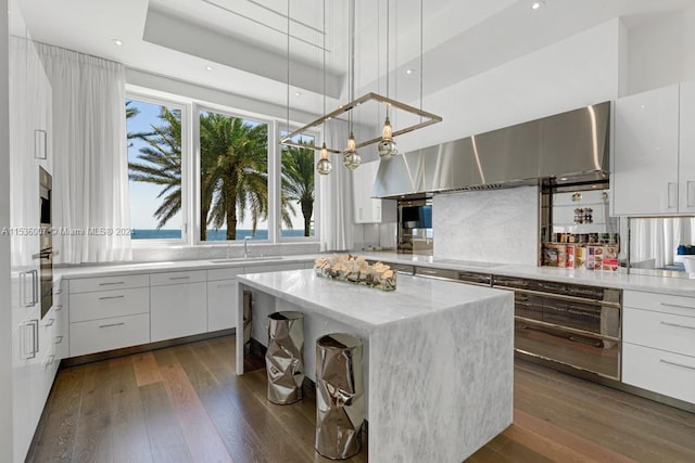 kitchen with decorative light fixtures, white cabinetry, and dark hardwood / wood-style floors