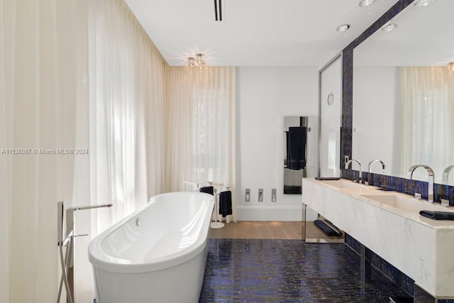 bathroom with hardwood / wood-style floors, a bathing tub, and oversized vanity