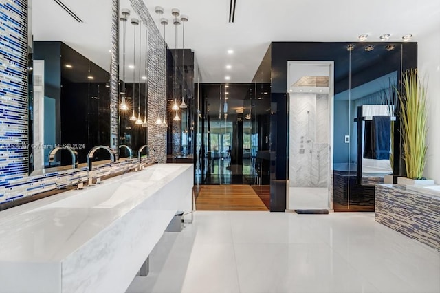 bathroom with tile floors, independent shower and bath, and sink