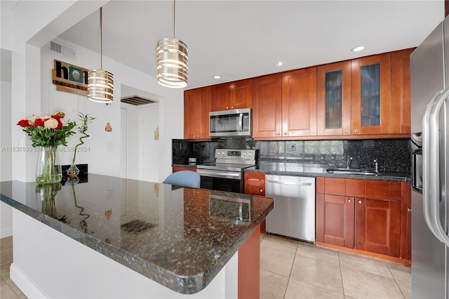 kitchen featuring light tile floors, backsplash, pendant lighting, and appliances with stainless steel finishes