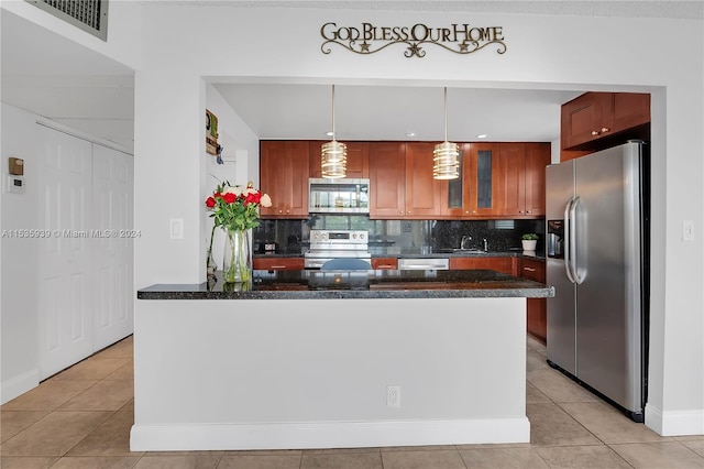 kitchen with appliances with stainless steel finishes, tasteful backsplash, light tile floors, and a kitchen island