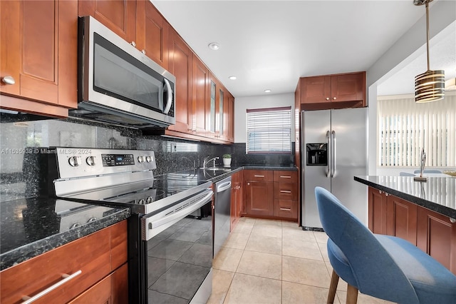 kitchen featuring appliances with stainless steel finishes, tasteful backsplash, plenty of natural light, and light tile floors