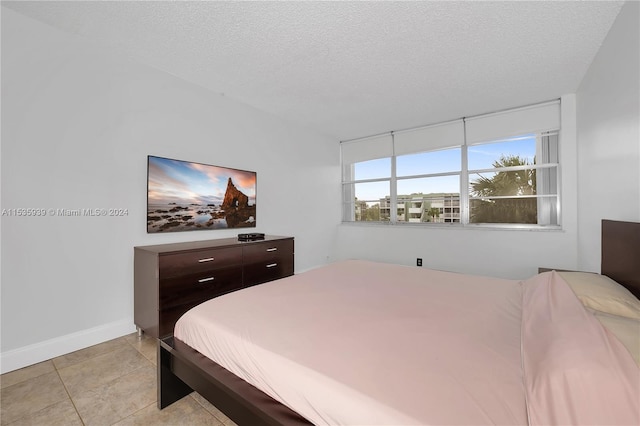 bedroom featuring a textured ceiling and light tile floors