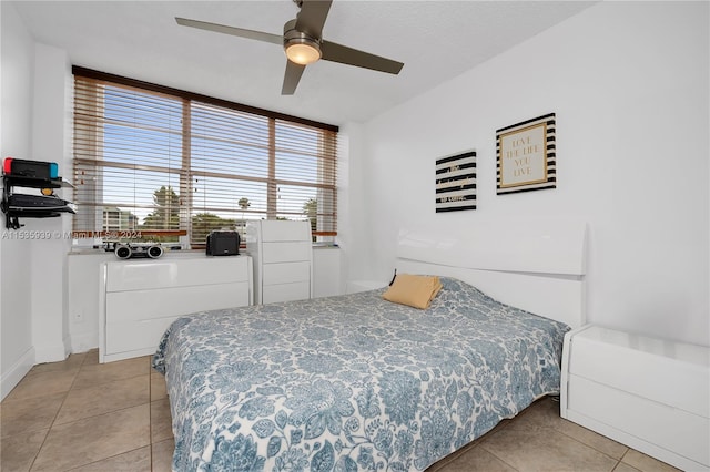 bedroom with ceiling fan and light tile floors