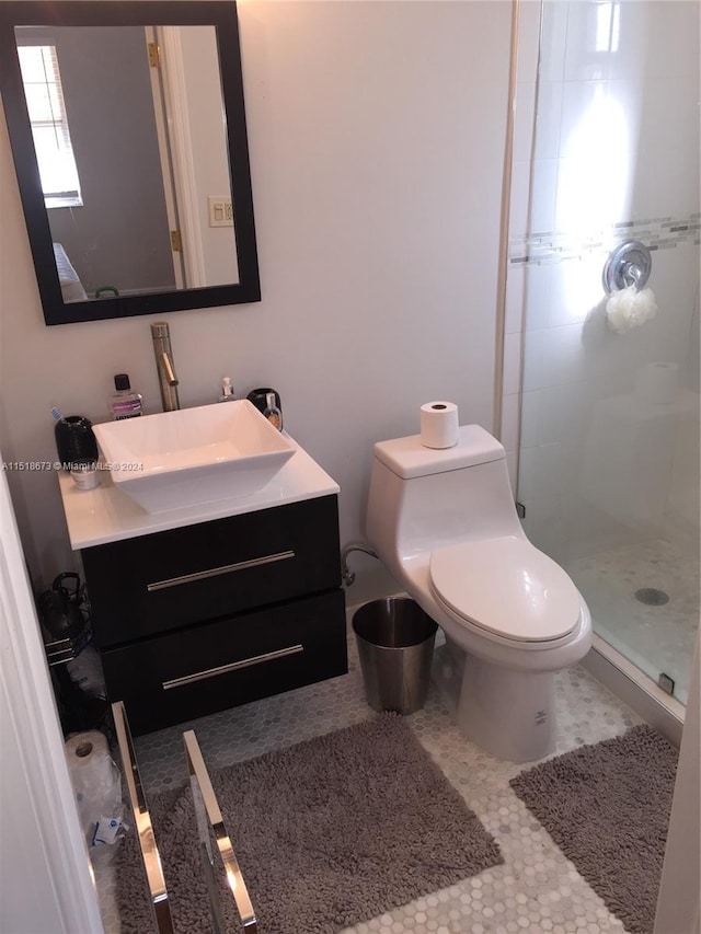 bathroom featuring toilet, tile floors, vanity, and tiled shower