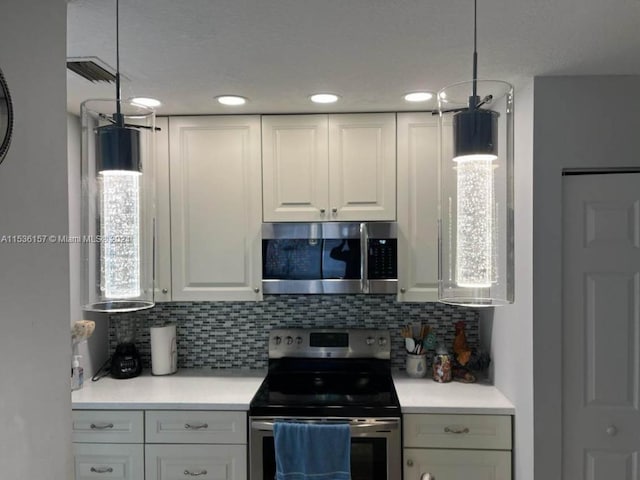 kitchen featuring white cabinetry, hanging light fixtures, tasteful backsplash, and stainless steel appliances