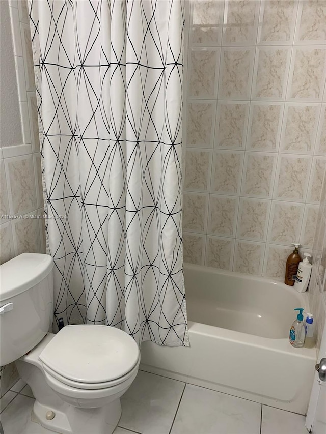 bathroom featuring tile flooring, tile walls, shower / bath combination with curtain, and toilet