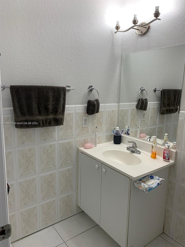 bathroom featuring tile walls, oversized vanity, and tile floors