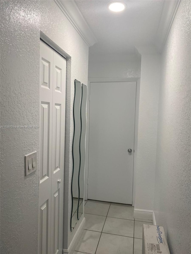 hall featuring light tile flooring and ornamental molding