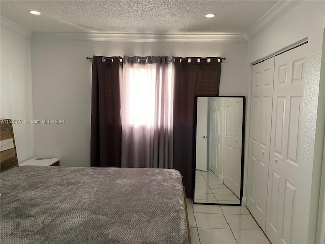 bedroom with a textured ceiling, crown molding, and light tile floors