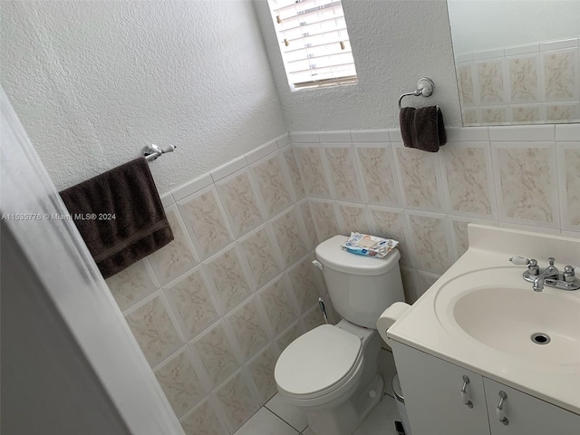 bathroom with tile walls, vanity, tile floors, and toilet