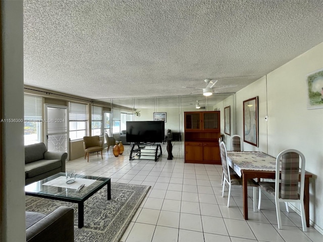 living room featuring light tile patterned floors, a textured ceiling, and ceiling fan