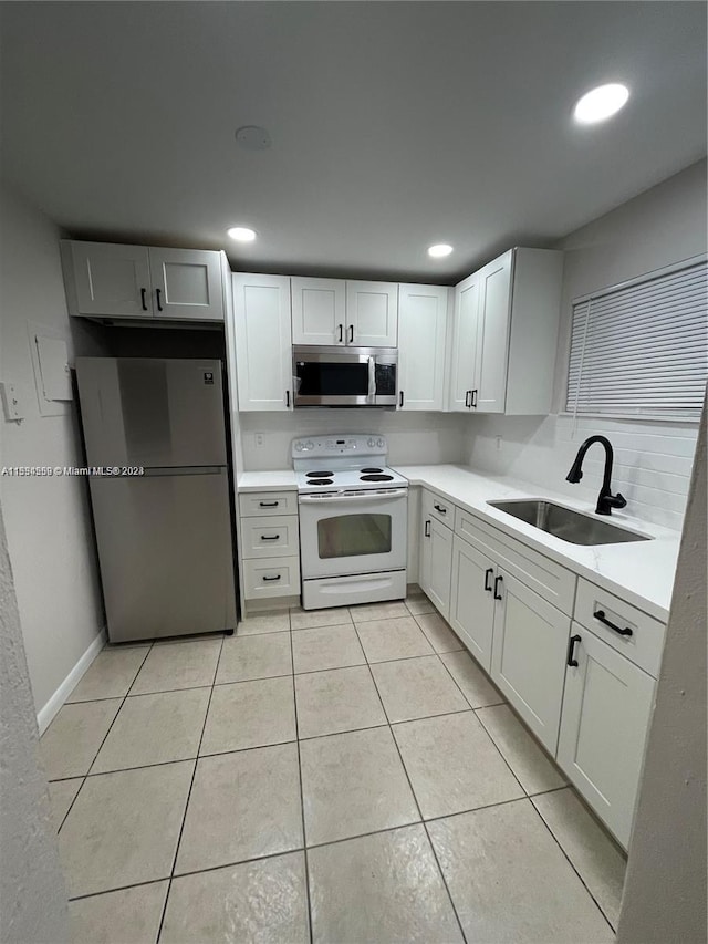 kitchen with sink, white cabinets, light tile flooring, and stainless steel appliances