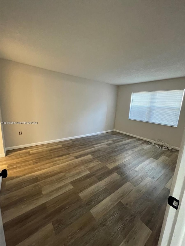 empty room with dark hardwood / wood-style flooring