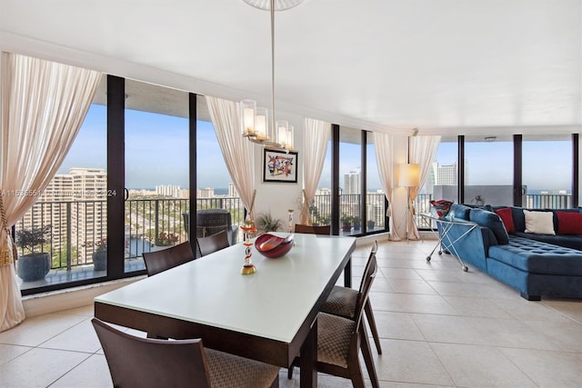 tiled dining room featuring a water view, a notable chandelier, expansive windows, and a wealth of natural light