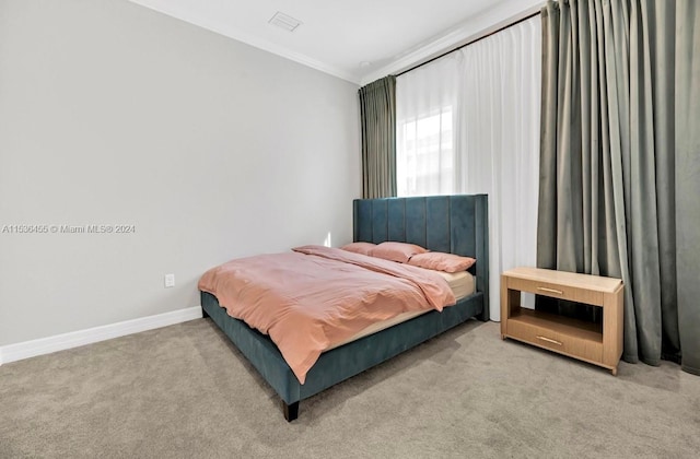 bedroom with crown molding and light colored carpet