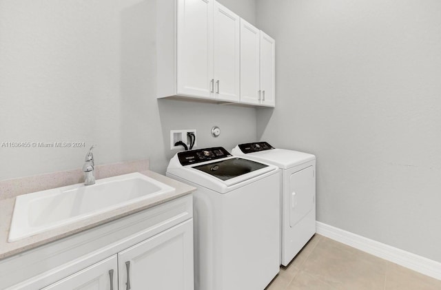 clothes washing area with washer hookup, light tile floors, cabinets, washer and dryer, and sink