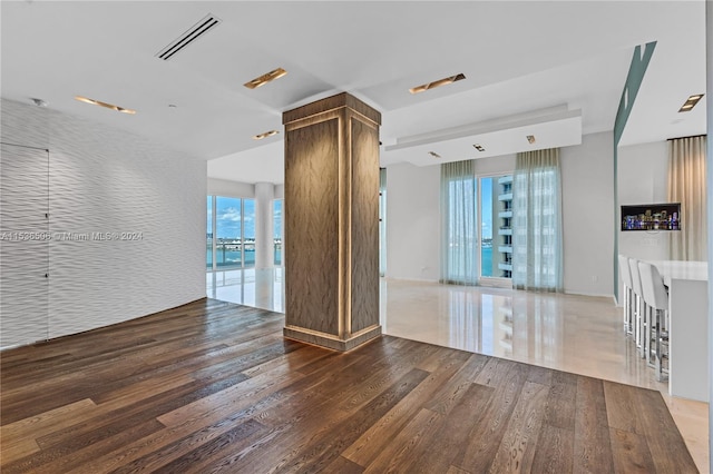 unfurnished living room featuring floor to ceiling windows and hardwood / wood-style floors