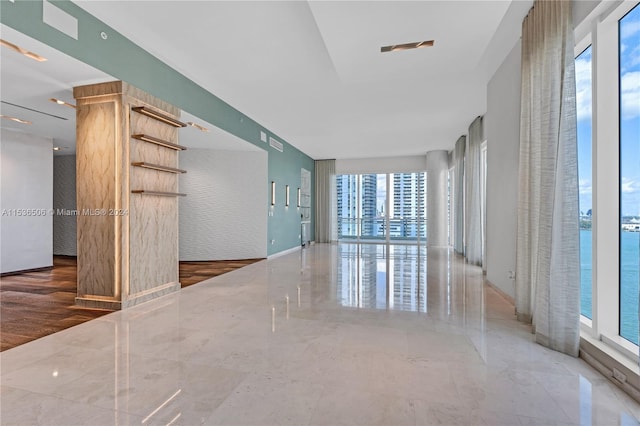 unfurnished room featuring tile flooring and a water view