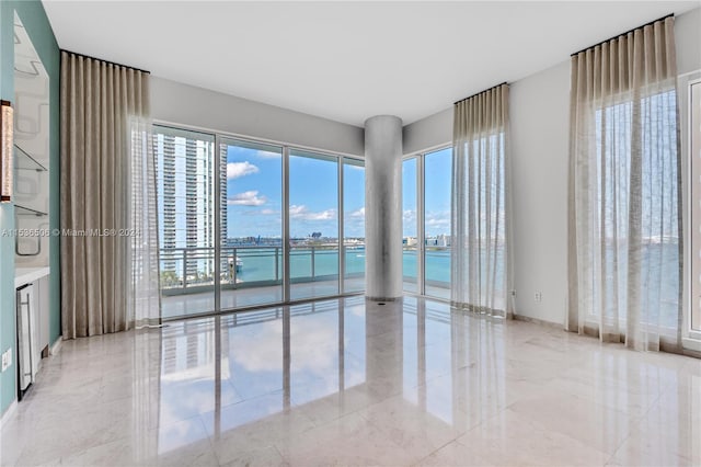 tiled empty room featuring a water view