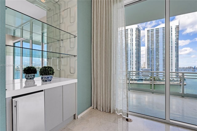 interior space featuring gray cabinetry, light tile flooring, and a water view