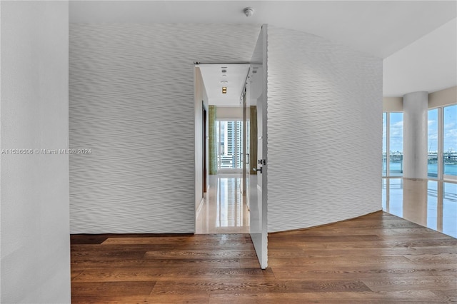 unfurnished room featuring dark wood-type flooring and a water view