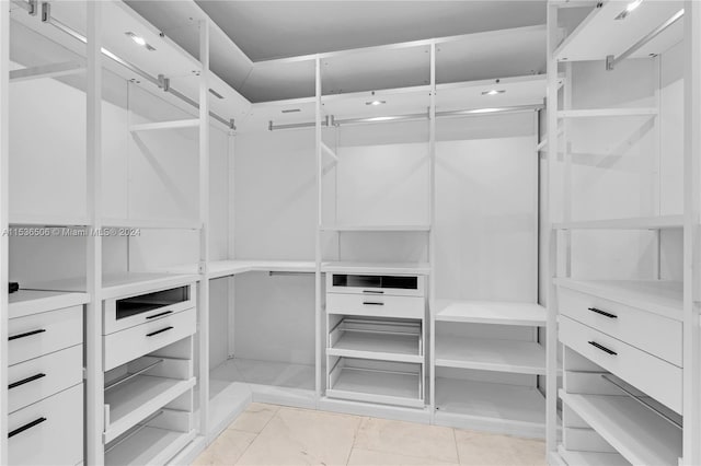 walk in closet featuring light tile floors