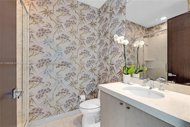 bathroom featuring a tile shower, tile floors, toilet, and vanity